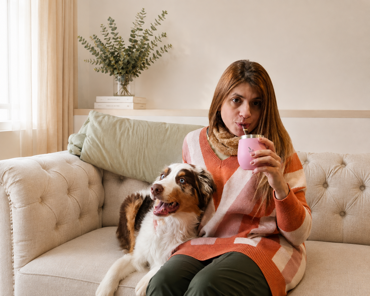 Carolina con su perro en el sillón, tomando mate en un momento de calma